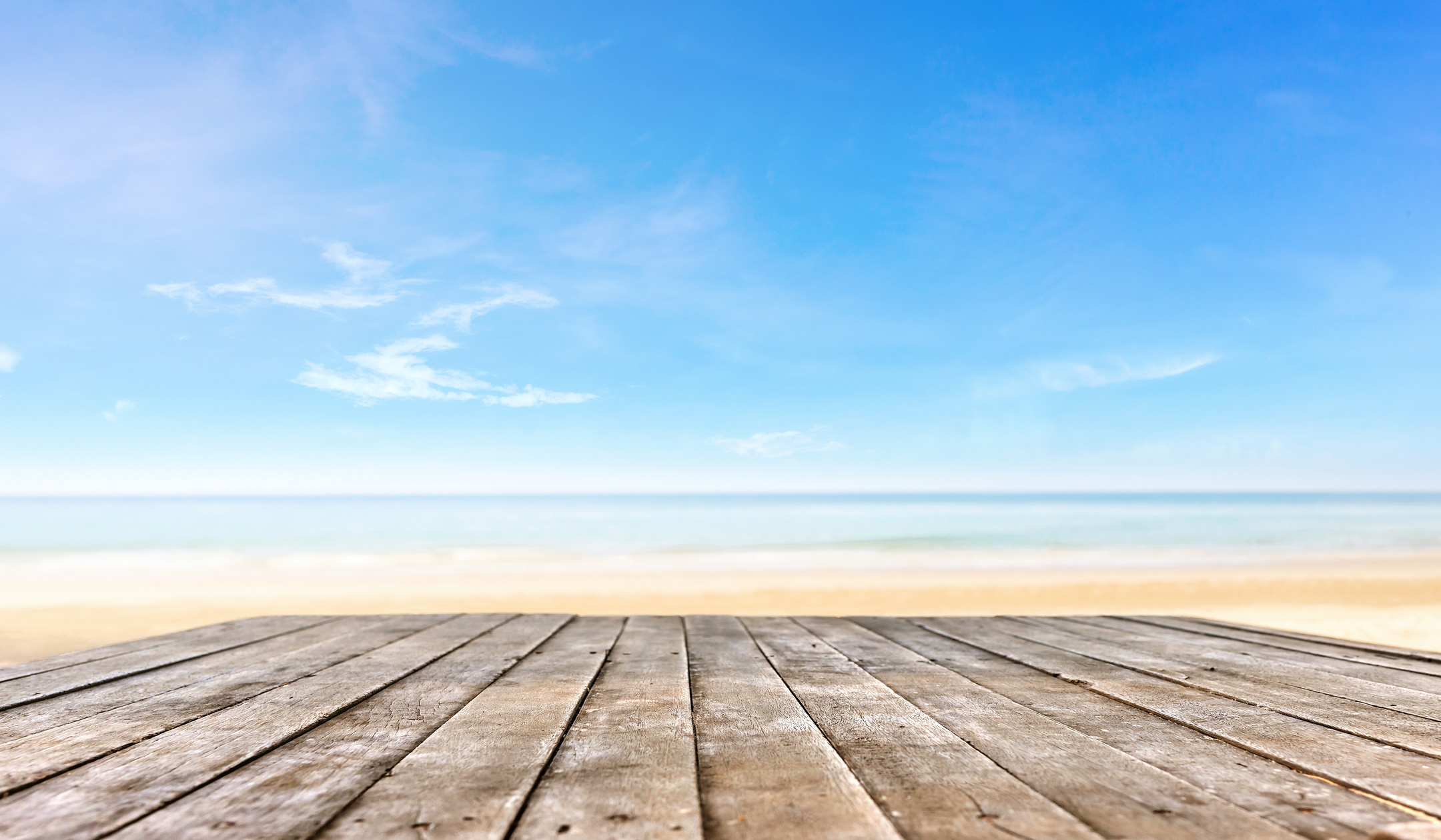 wooden table top or wooden plank in front of the beach background for products or object display